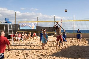 A beach volleyball game with players and spectators on a sandy court. - Monéa Royal Mónica (Yaiza)