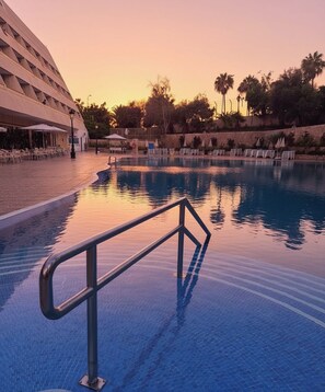 Una piscina al aire libre, sillones reclinables de piscina