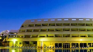 Un hôtel à plusieurs étages avec une piscine située à l’avant.