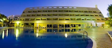 Een buitenzwembad en ligstoelen