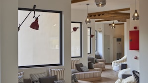 A modern interior with seating areas, large windows, and hanging pendant lights. - tent Palmanova (Calvia)