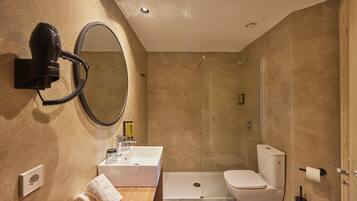 Een moderne badkamer met een ingebouwde haardroger, een wastafel, toilet en douche.