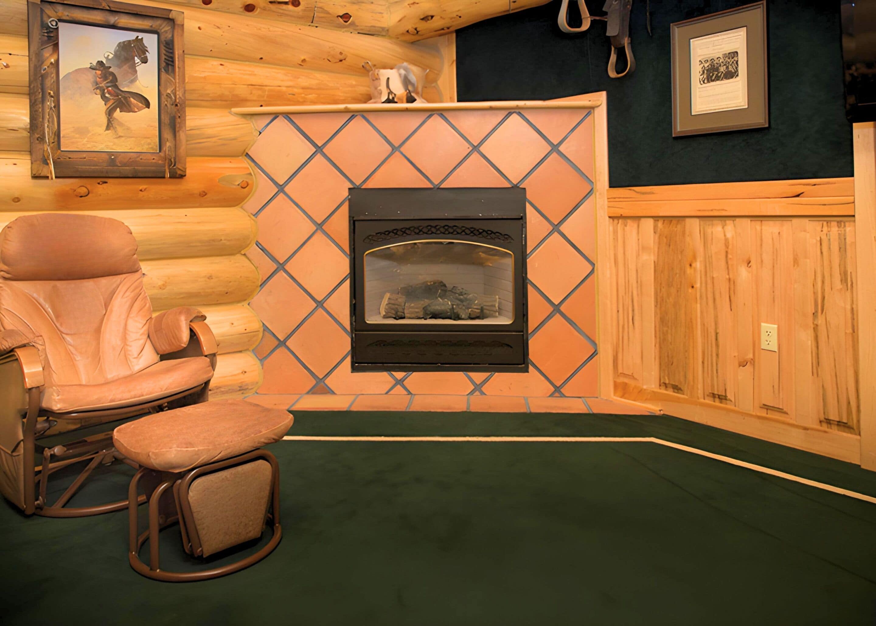 A log cabin interior with a fireplace, a rocking chair, and a framed picture on the wall.