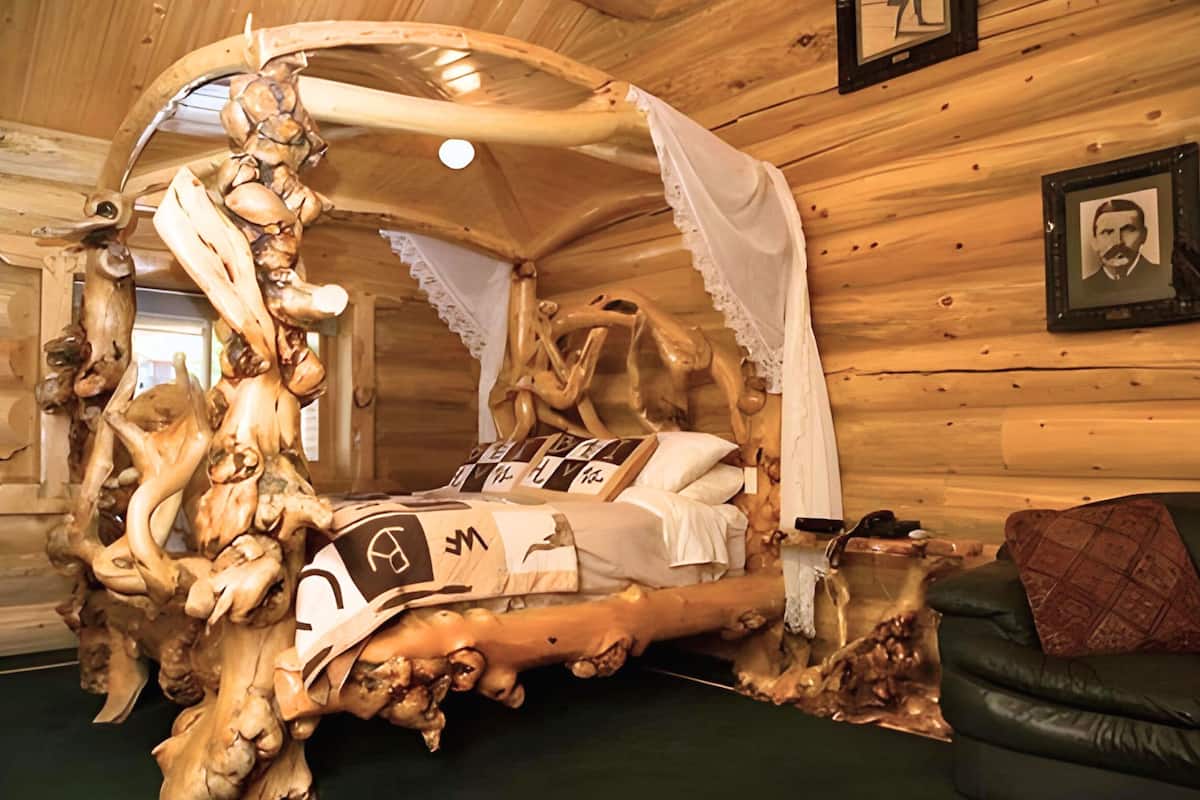 Un lit au design original, agrémenté d’éléments en bois sculpté et surmonté d’un baldaquin.