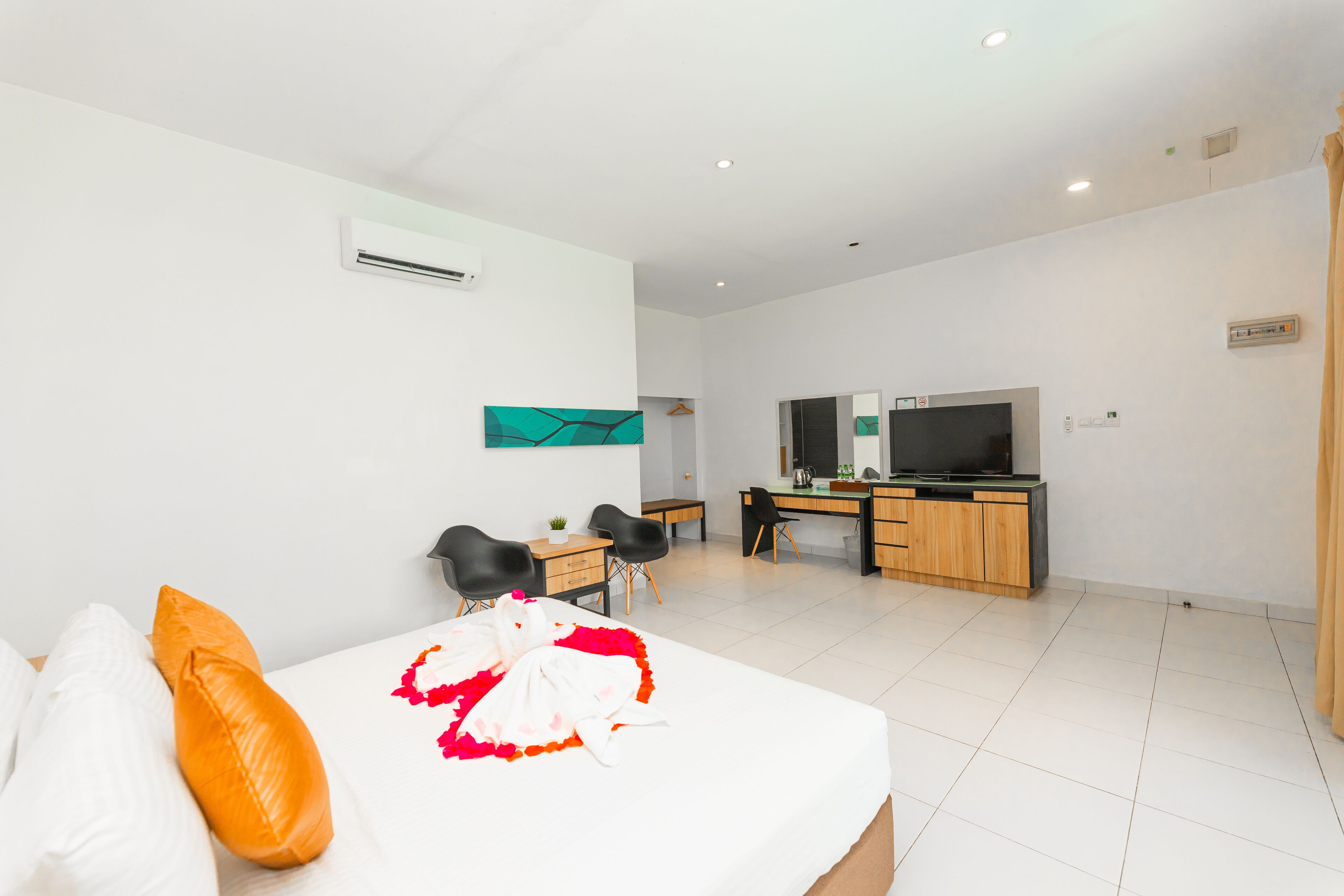 Une chambre d’hôtel moderne équipée d’un lit, d’un bureau et d’une télévision.