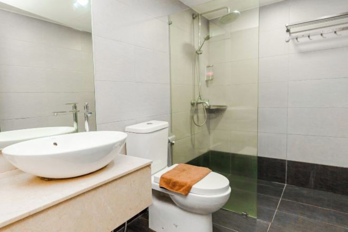 Ein Badezimmer mit weißem Waschbecken, WC und einer Duschkabine.