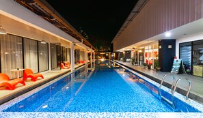 A hotel pool area with a clear pool, sun loungers, and a bar area. - The Villa Langkawi (Langkawi)