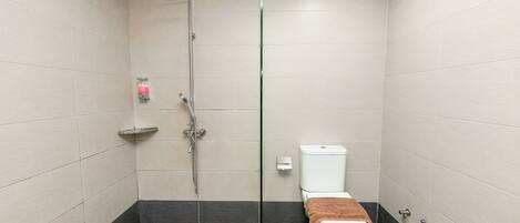 A modern bathroom with a shower, toilet, and a towel rack.