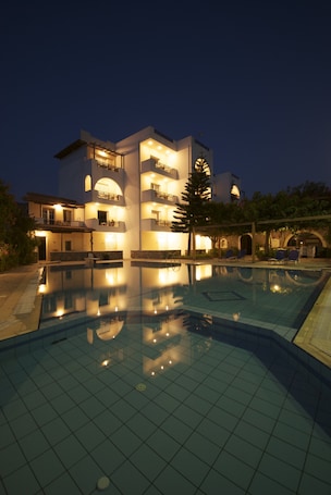 Una piscina al aire libre, sombrillas, sillones reclinables de piscina. Sarikampos Beach