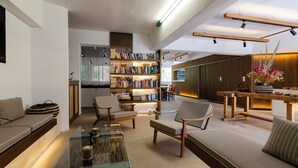 En moderne stue med sofa, stole, sofabord og bogreol.