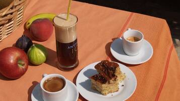 Una mesa con una bebida, una porción de pastel y frutas.