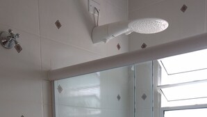 Un baño con cabina de ducha de vidrio, inodoro y lavamanos.