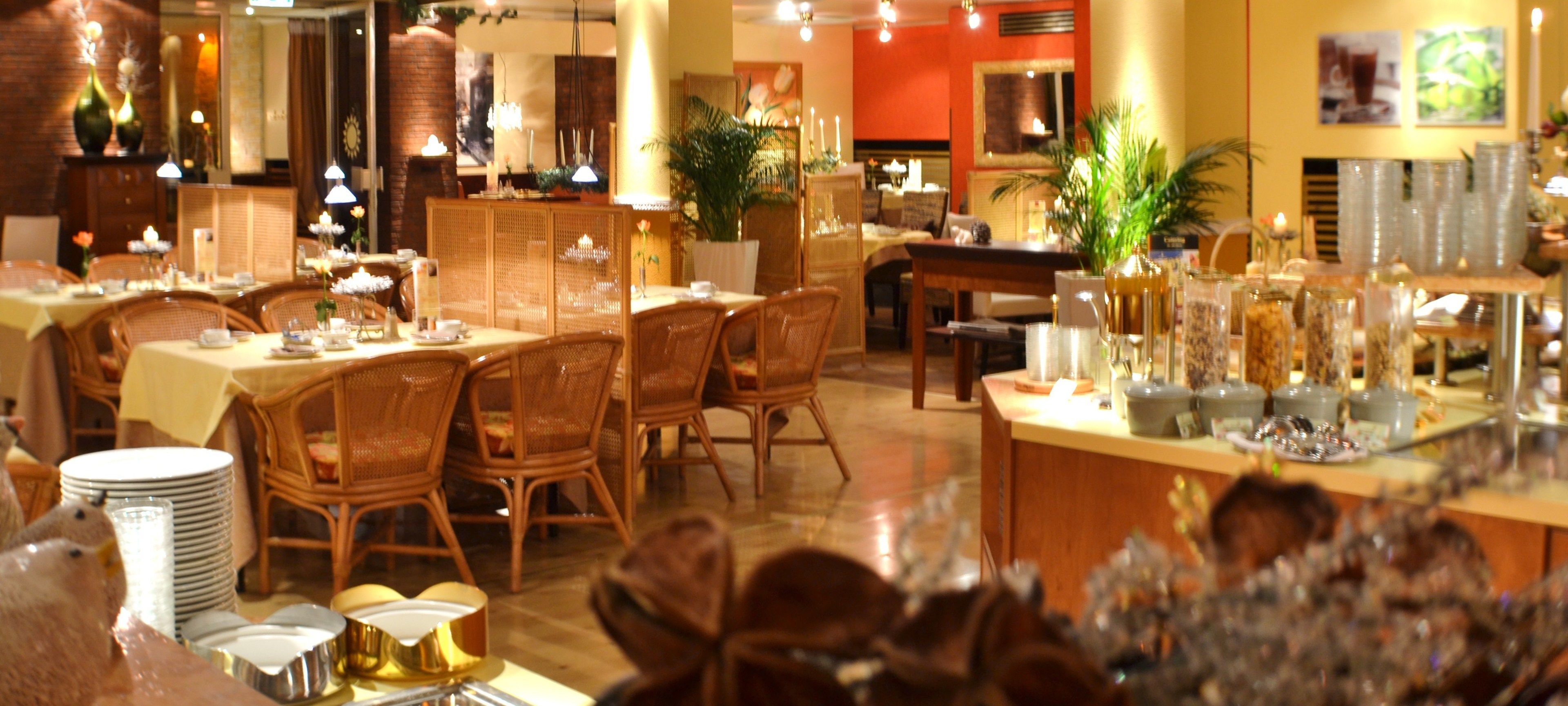 A restaurant with multiple dining tables and chairs, a bar area, and various decorative items.