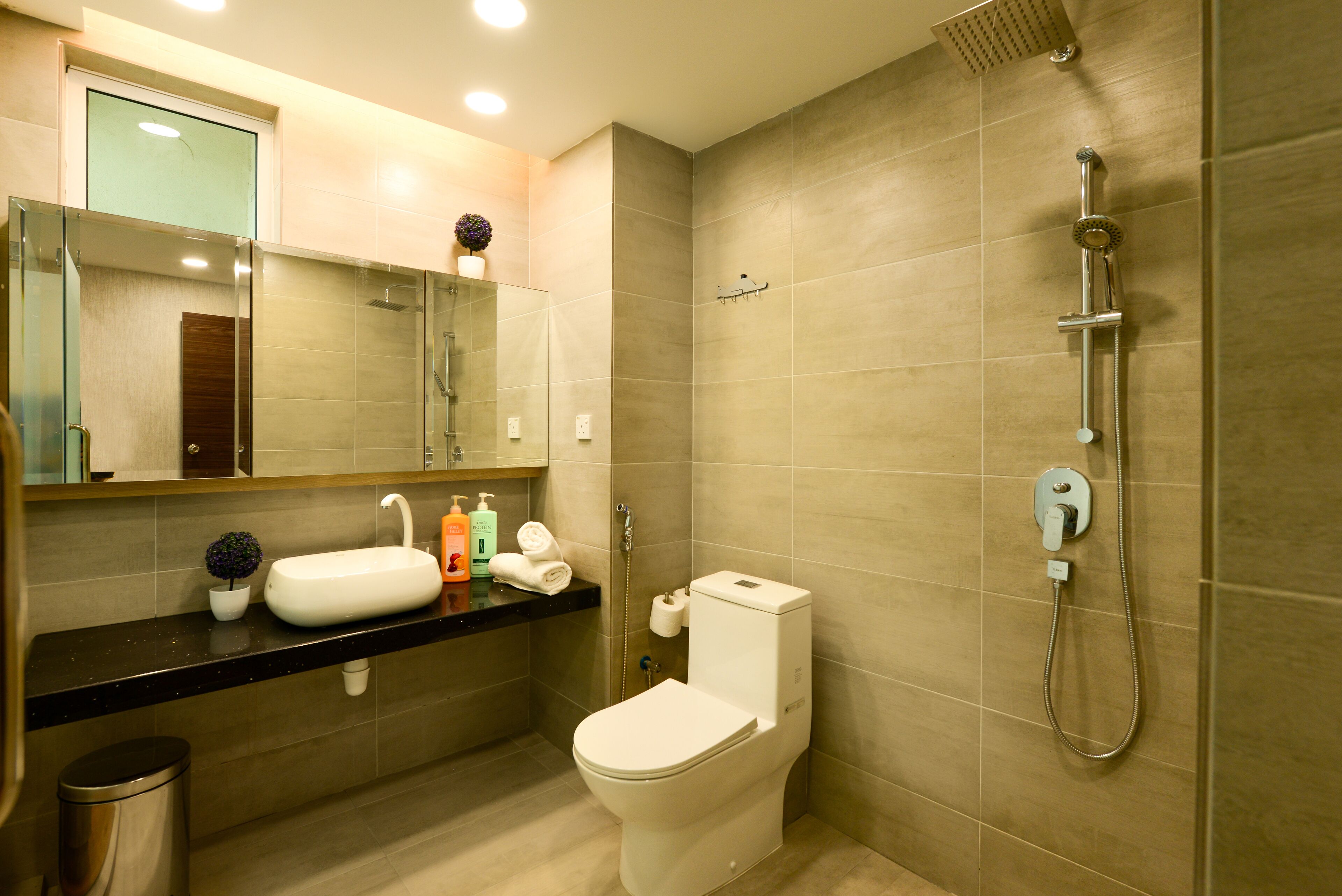 Un baño moderno con inodoro, lavamanos y ducha.