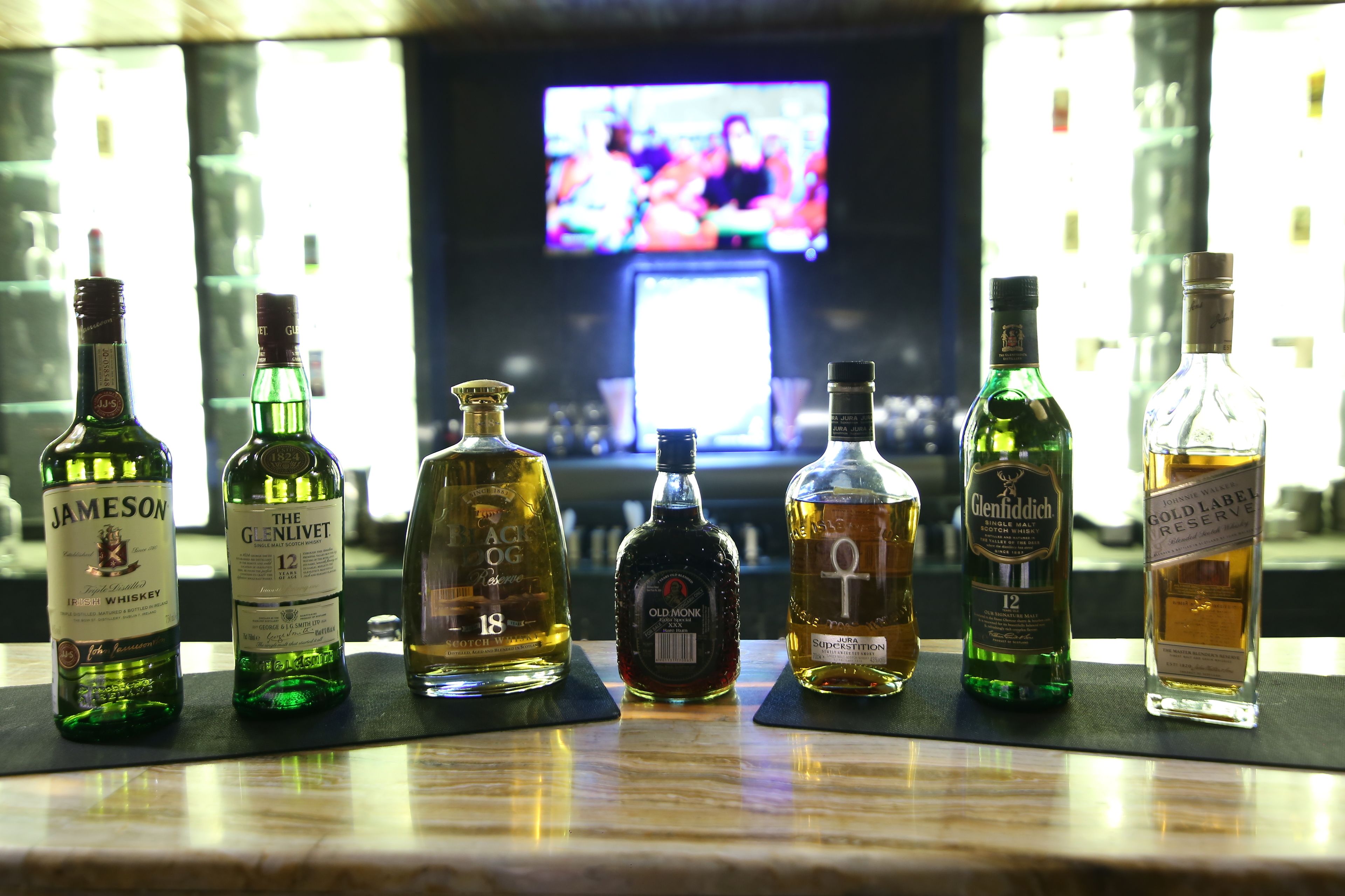 Un bar con varias botellas de licor expuestas en la barra.