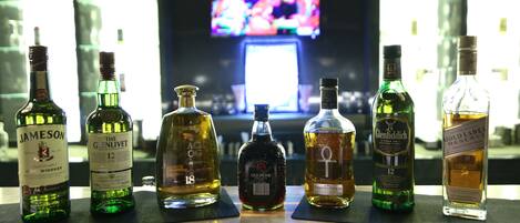 Un bar con varias botellas de licor expuestas en la barra.
