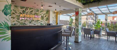 A reception area with a modern design, featuring a reception desk, seating area, and a large window providing a view of the outside.