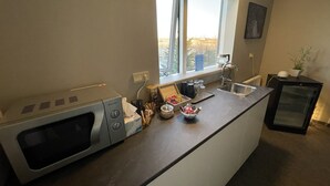 Cozinha moderna com micro-ondas embutido, pia e janela com vista para o exterior.