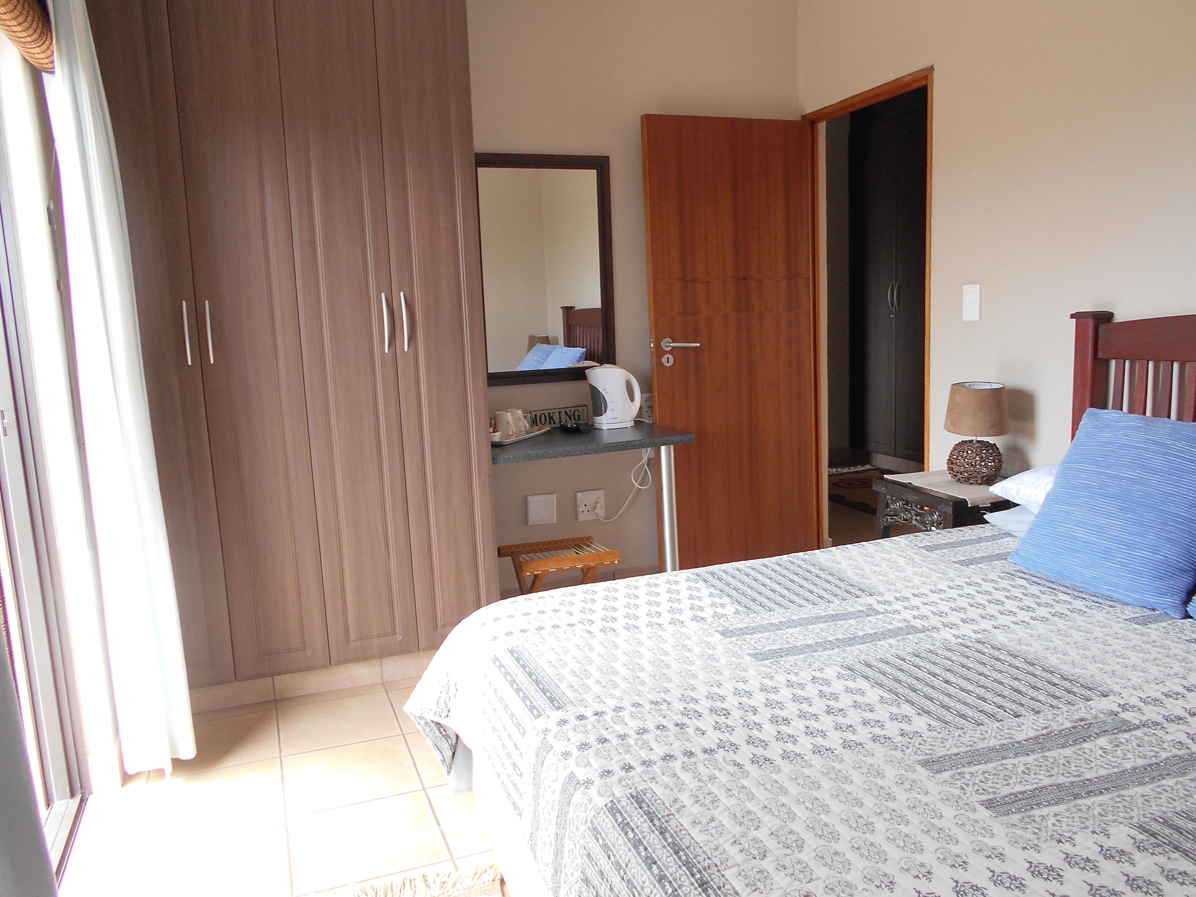 Une chambre à coucher comprenant un lit, une armoire, un bureau et une table de chevet.