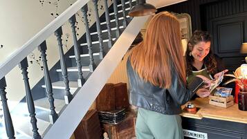 Una persona revisa un menú en un restaurante con una escalera y decoración de estilo antiguo al fondo.