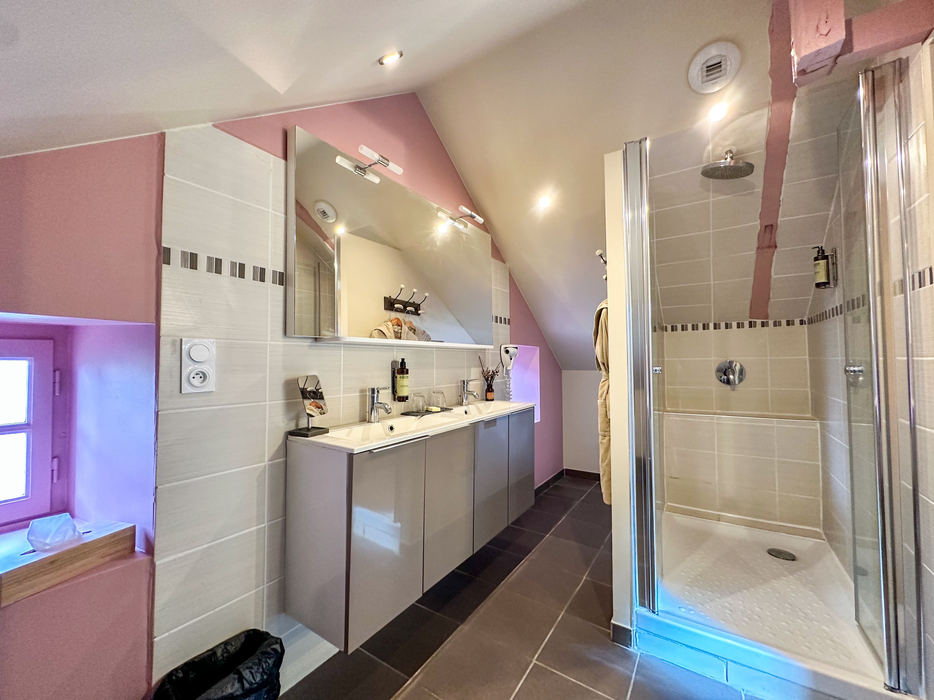 Une salle de bain moderne avec une douche à l’italienne, un meuble-lavabo avec un miroir et une fenêtre.