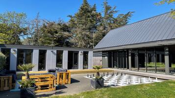 A modern building with large windows and a courtyard with a chessboard.