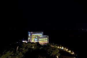 A multi-story building with a unique, colorful facade at night.