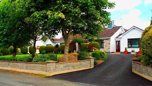 A residential street with houses, a paved road, and well-maintained hedges. - Fortview House Bed & Breakfast (Belturbet)