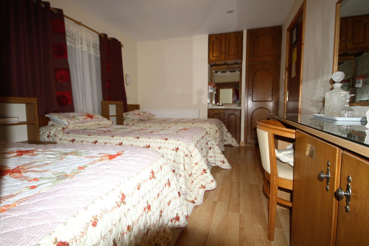 Ein Schlafzimmer mit zwei Betten, Holzmöbeln und einer Küchenzeile.