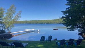 A lakeside view with dock, chairs, and a grassy area. - Highland Lake Resort (Bridgton)