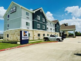 Un hotel de varios pisos con fachada de piedra y un letrero que dice Hallmarc Studios.