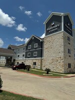 Un edificio con letrero de 'Hallmark Studios', con fachada de piedra y varias ventanas.