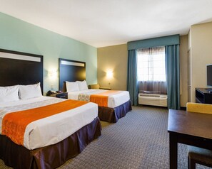 A hotel room with two beds, a desk, a chair, a television, and a window with curtains. - Hallmarc Studios (Port Arthur)