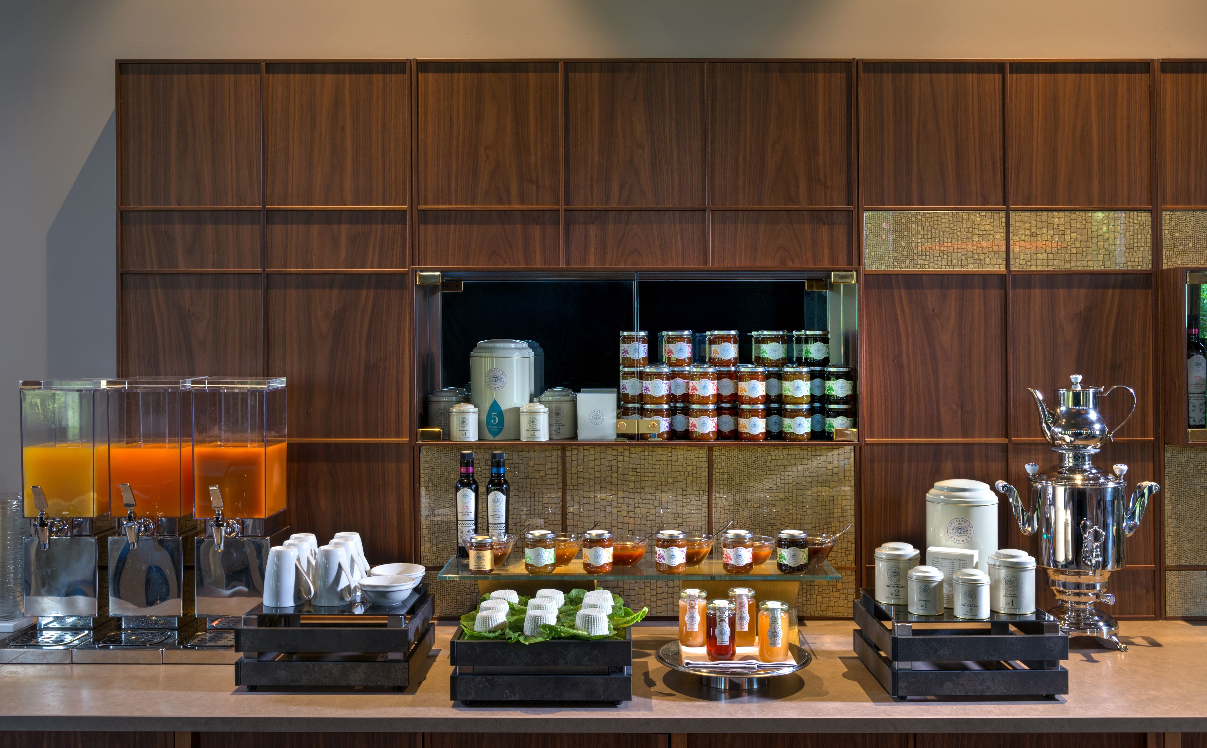 Ein Frühstücksbuffet mit Kaffeeautomaten, Teeausgabestationen und einer Auswahl an Speisen und Getränken.
