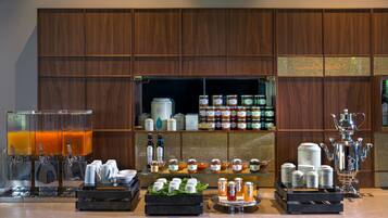 A breakfast bar with coffee machines, tea dispensers, and a variety of food and drink options.
