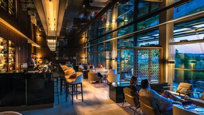 A modern bar area with seating and a bartender. - Palazzo di Varignana Resort & SPA (Castel San Pietro Terme)