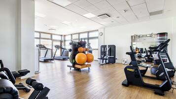 A gym with treadmills, weight machines, and exercise balls.
