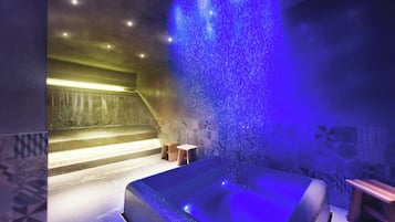 Relax in a serene spa room with a large hot tub and geometric-patterned wall.