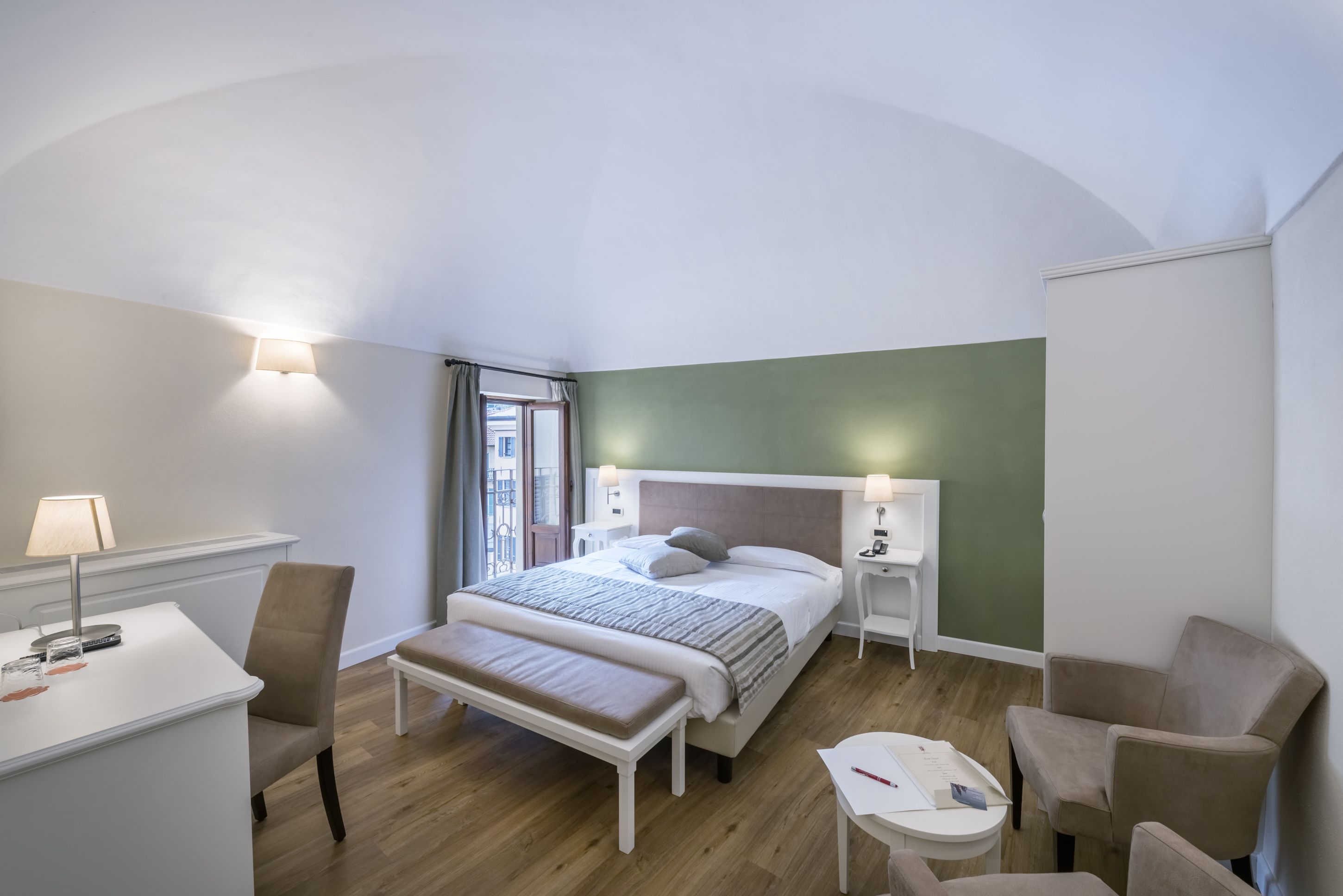 Ein modernes Schlafzimmer mit einem großen Bett, Nachttischen, einem Schreibtisch und einem Stuhl.