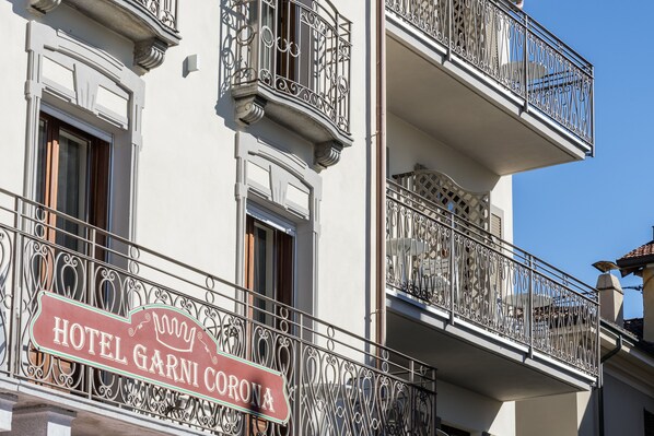 A hotel sign with ornate iron railings and a clear blue sky in the background.