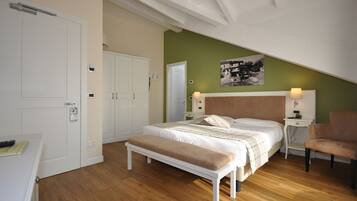 Een slaapkamer met een bed, een bankje, nachtkastjes en een stoel.