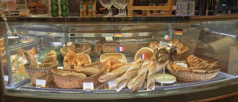 A bakery display case with various breads and pastries.