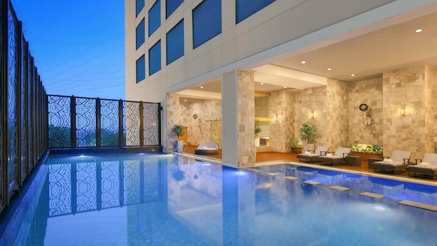 Un área interior de piscina moderna con vista despejada, sillones de descanso y ambiente luminoso.