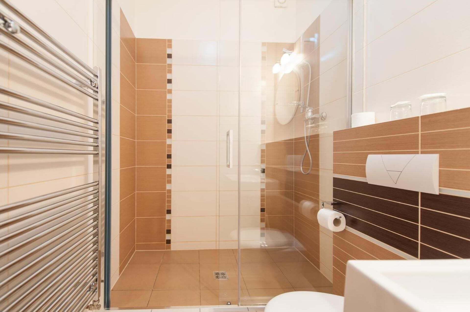 A modern bathroom with a glass shower enclosure, a toilet, and a towel rack.