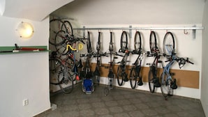 A bike storage area with multiple bicycles and a small blue chair. - Hotel v Centru (Ceske Budejovice)