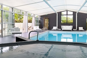 Una piscina techada, sillones reclinables de piscina