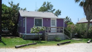 A small, single-story house with a purple exterior and a white door.