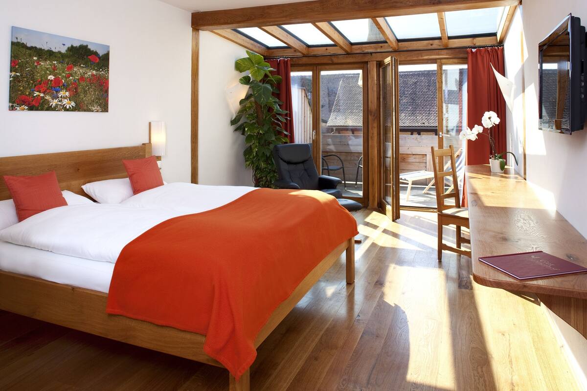 Een slaapkamer met een bed, een bureau en een stoel.