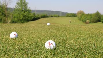 Ein Golfplatz mit drei Bällen auf dem Rasen.