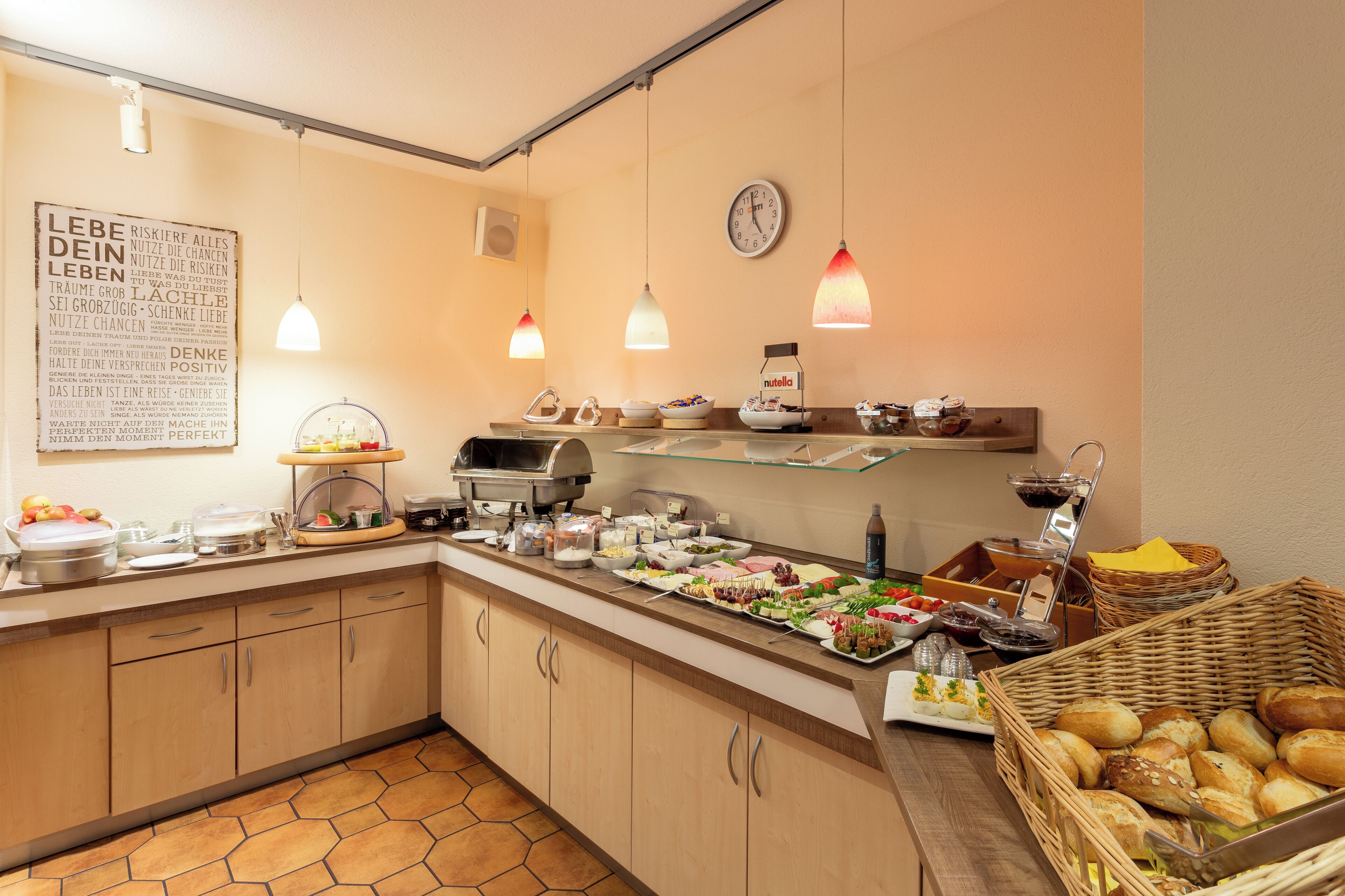 Ein reichhaltiges Buffet mit verschiedenen Speisen, einer Uhr und hängenden Pendelleuchten.